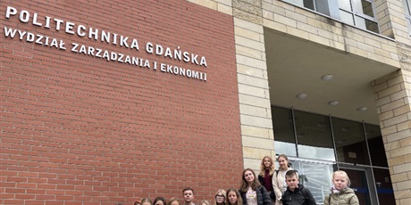 Powiększ grafikę: Grupa  uczniów  stoi  na  schodach  przed  gmachem  Politechniki  Gdańskiej.