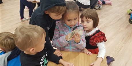 Powiększ grafikę: Grupa  dzieci  ogląda  banknot  pod  lupą