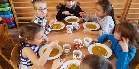 Powiększ grafikę: Przy stoliku dzieci  zajadające  zupę  z  dyni
