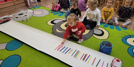 Powiększ grafikę: Dzieci segregują kredki wg koloru.