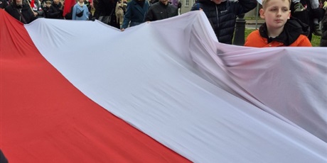 Powiększ grafikę: Polska flaga niesiona przez uczestników parady.