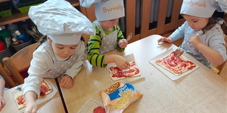 Powiększ grafikę: Dzieci przygotowują swoje pizze.