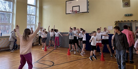 Powiększ grafikę: Uczniowie wraz z nauczycielami w szkolnej sali gimnastycznej