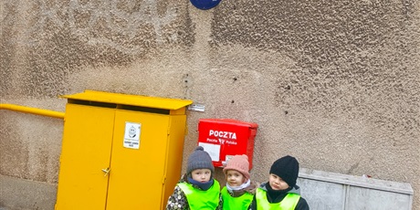 Powiększ grafikę: dzieci ustawiają się do przed znaczkiem Poczty Polskiej.