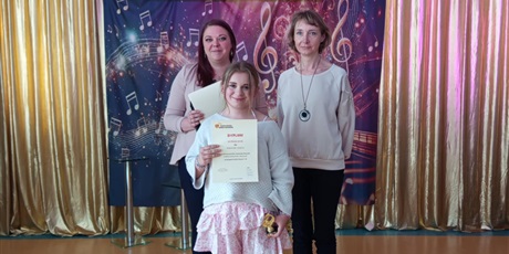 Powiększ grafikę: Uczennica z dyplomem.