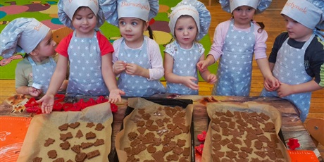 Powiększ grafikę: Dzieci pokazują swoje, gotowe do pieczenia, pierniczki.
