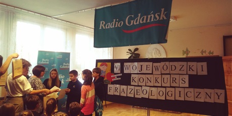 Powiększ grafikę: Dzieci  odbierające  nagrody. W  tle  napis  VI  Wojewódzki  Konkurs  Frazeologiczny. U góry  wisi  napis  Radio Gdańsk.