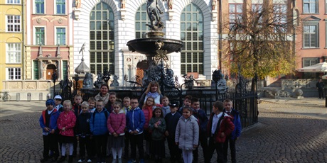 Powiększ grafikę: Grupa  dzieci  stoi  przed  fontanną  Neptuna.
